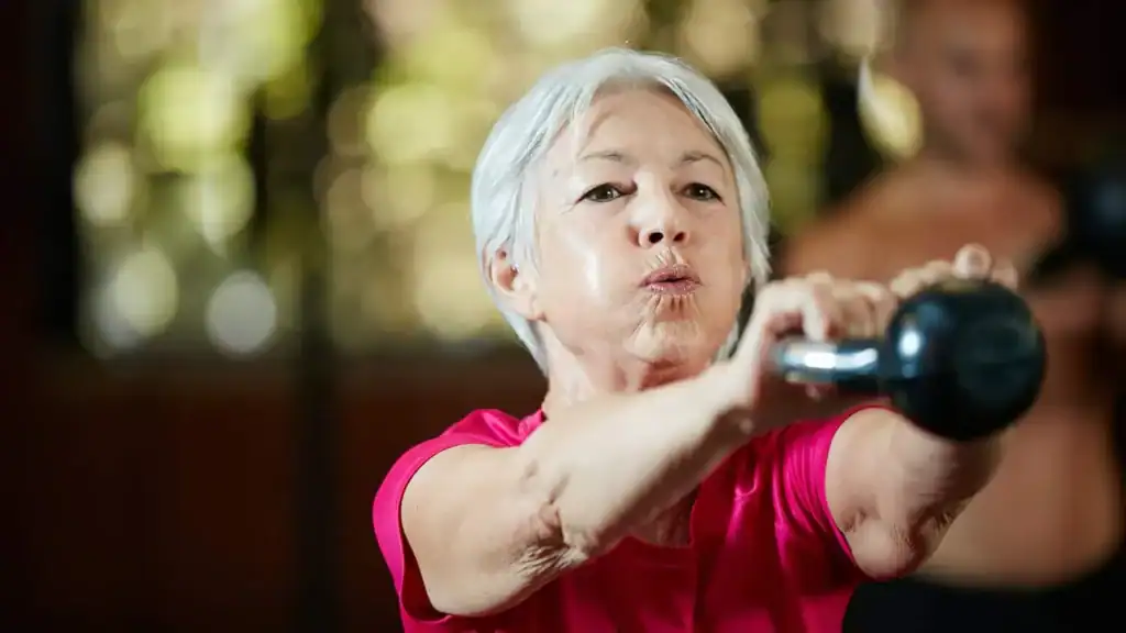 Older woman doing weight training Folkestone to help her strength and longevity 