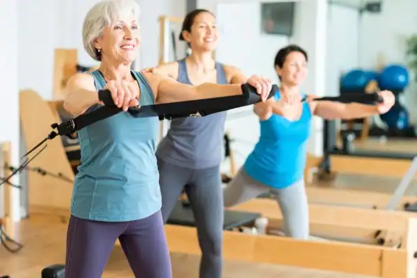 Toning Arms After 60: Empowering Womens Fitness Through Effective Weight Training 2 older woman doing weight training Folkestone and resistance in the gym to tone upper arms