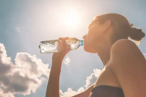 Hydration: The Secret Ingredient for a Toned Stomach and Enhanced Fitness 3 Image of woman drinking water to hydrate Folkestone after run.