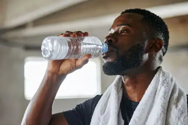 Hydration: The Secret Ingredient for a Toned Stomach and Enhanced Fitness 1 Image of man drinking water to improve hydration Folkestone after work out.